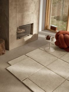 a living room with a fire place in the corner and rugs on the floor