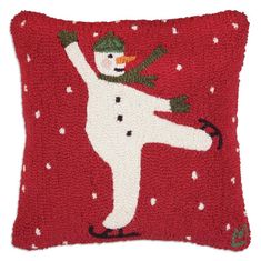 a red pillow with a snowman on it's back and arms in the air