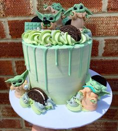 there is a cake with green icing and cookies on the top that has baby yoda's in it