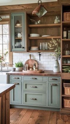 a kitchen with green cabinets and wooden floors