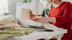 a woman using a sewing machine to sew clothes