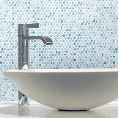 a white bowl sink sitting on top of a counter next to a faucet