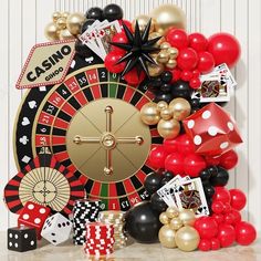 a casino themed party with balloons, dices and other items on the table in front of it