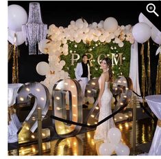 a bride and groom are standing in front of the letters for their wedding ceremony at night