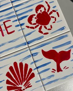 four handprinted tiles with red and blue designs on them that say life, love, crab