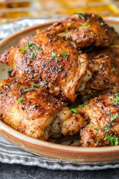 baked chicken thighs on a plate with parsley in the foreground and text overlay that reads baked chicken thighs