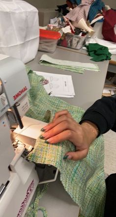 a woman is using a sewing machine to sew fabric