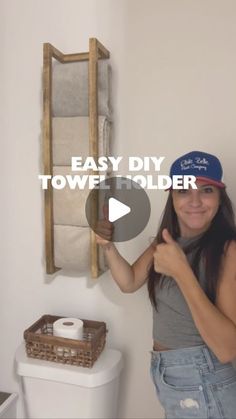 a woman standing in front of a toilet holding up a towel holder with the words easy diy towel holder on it