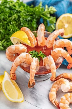 shrimp in a bowl with lemon wedges and parsley