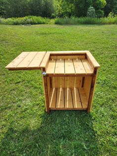 a wooden table sitting on top of a lush green field