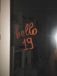 the reflection of a person standing in front of a mirror with writing on it that reads hello 19