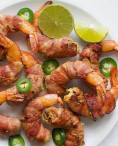 shrimp skewers with jalapenos and limes on a white plate