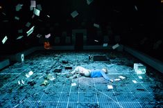 a person laying on the ground surrounded by confetti and paper flying in the air