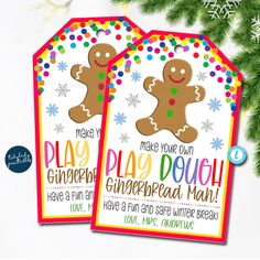 two christmas tags with gingerbread man and snowflakes on them, next to a pine tree