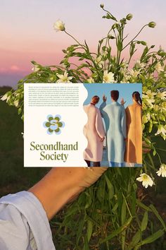 a person holding up a book with pictures of women in dresses and flowers on it