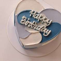 a blue and white heart shaped cake with the words happy birthday written on it's side