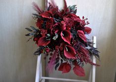 a bouquet of flowers sitting on top of a white chair in front of a wall