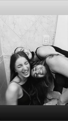 three women are laughing in the bathroom together