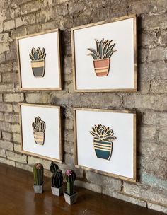 three framed pictures on a brick wall with succulents and cactus in pots