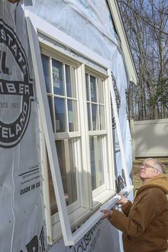 a man standing in front of a window with some tape on the side of it