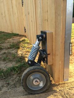 a wheel attached to the side of a wooden fence