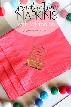 graduation napkins with gold foil on them and pom - poms around the edges