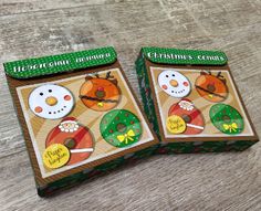 two boxes with christmas ornaments on them sitting on a table