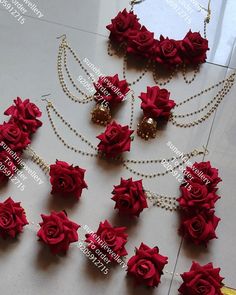 red roses and pearls are arranged on a white table with gold chains, necklaces and earrings