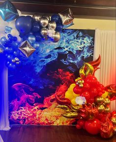 balloons and streamers are set up in front of a large wall with an artistic painting on it