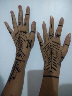 two hands that have tattoos on them and arrows painted on the palm of each hand