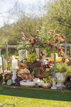 a table topped with lots of different types of food and candles on top of it