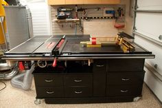 a workbench in a garage with tools on the top and drawers below it