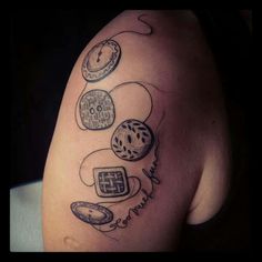 a woman's arm with tattoos on it and various items in the shape of clocks