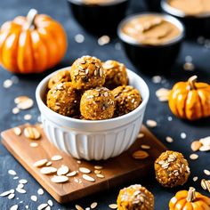 a bowl filled with oatmeal energy bites on top of a wooden cutting board