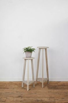 two wooden stools with a plant on one side and a potted plant on the other