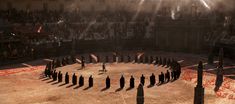 a group of people standing in the middle of a circle surrounded by poles and pillars