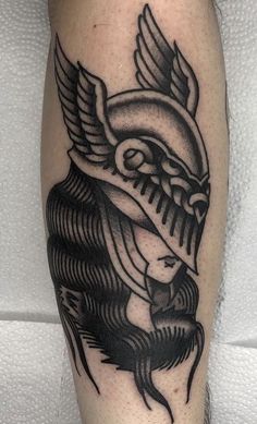 a black and white tattoo on the leg of a man with an eagle head in it