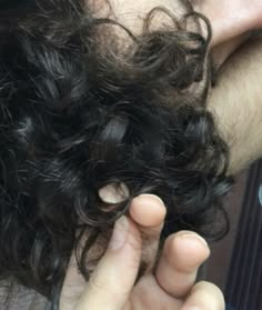 a close up of a person's hair with one hand on the other side of his head