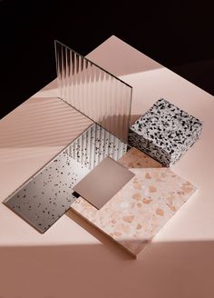 four different types of paper sitting on top of a pink table with black and white designs