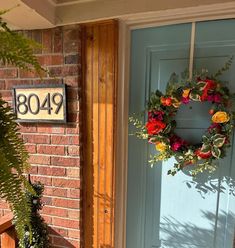 a blue front door with a wreath on it