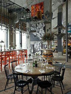 an empty restaurant with tables and chairs in the center, surrounded by art work on the walls