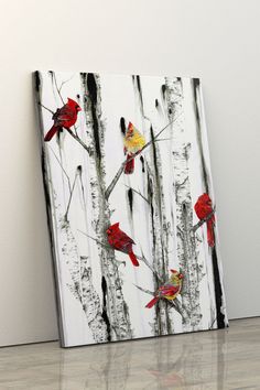 three red birds perched on the branches of a birch tree