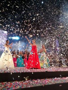 two women in dresses standing on stage surrounded by confetti