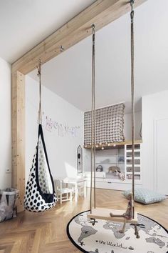 a child's bedroom with two swings and a rug on the floor in front of it