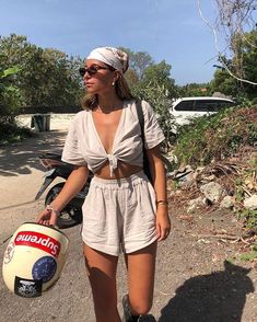 a woman walking down the road with a helmet on her head