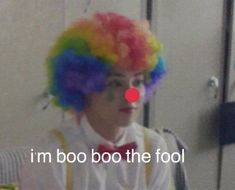 a man with clown makeup and colorful hair in front of a mirror that says, i'm boo boo the fool