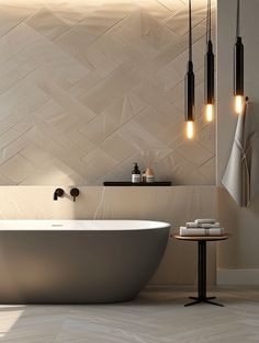 a white bath tub sitting next to a table with two lights on top of it