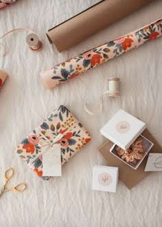 wrapping supplies are laid out on a bed with twine spools and scissors