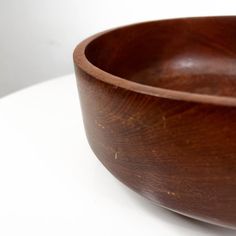 a wooden bowl sitting on top of a white table