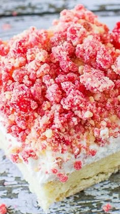 a piece of cake with white frosting and red sprinkles on top